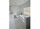 A spacious bathroom features a soaking tub with tile surround, and double vanity sinks at 7044 Brickell Ct, Spring Hill, FL 34609