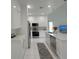 Bright, modern kitchen features white cabinets, stainless steel appliances, and stylish pendant lighting at 7044 Brickell Ct, Spring Hill, FL 34609