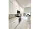 Modern kitchen boasts white cabinets, stainless steel appliances and views into the living area at 7044 Brickell Ct, Spring Hill, FL 34609