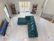 Bright living room with white tile floors, turquoise sectional sofa, and large windows at 7044 Brickell Ct, Spring Hill, FL 34609