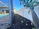 View of the pool from the backyard, featuring new mulch and a white privacy fence at 7114 Parrot Dr, Port Richey, FL 34668