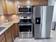 Stainless steel appliances in a kitchen with granite countertops and wood cabinetry at 7114 Parrot Dr, Port Richey, FL 34668
