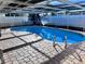 Inviting in-ground pool with pavers, cage and convenient entry steps at 7114 Parrot Dr, Port Richey, FL 34668