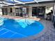 Outdoor view of the bright blue in-ground pool with surrounding deck and cage at 7114 Parrot Dr, Port Richey, FL 34668