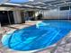 Beautiful in-ground caged pool, with outdoor grilling area and stainless steel fridge at 7114 Parrot Dr, Port Richey, FL 34668