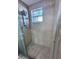 Shower with glass door, tiled walls, and decorative glass window at 7114 Parrot Dr, Port Richey, FL 34668