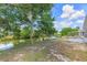 Backyard view of the canal with mature trees and lush landscaping at 7336 Cherry Laurel Dr, Port Richey, FL 34668