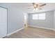 Bright bedroom with light-colored walls, wood floors, a ceiling fan, and an ensuite bathroom at 7336 Cherry Laurel Dr, Port Richey, FL 34668