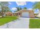 Inviting single-story house featuring a lush green lawn, attached garage, and neutral paint scheme at 7336 Cherry Laurel Dr, Port Richey, FL 34668