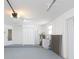 Garage with utility sink, white walls, gray epoxy floors, and storage closet at 7336 Cherry Laurel Dr, Port Richey, FL 34668