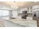 Modern kitchen features stainless appliances, a center island with granite countertops, and white cabinets at 7336 Cherry Laurel Dr, Port Richey, FL 34668