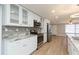 Updated kitchen includes stainless appliances, granite counters, tile backsplash, and glass front cabinets at 7336 Cherry Laurel Dr, Port Richey, FL 34668