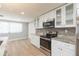 Bright kitchen features new stainless appliances, white cabinets, granite countertops and wood-look floors at 7336 Cherry Laurel Dr, Port Richey, FL 34668