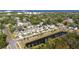 A neighborhood aerial view reveals modern homes near a pond with a scenic coastal backdrop at 7513 S Sherrill St, Tampa, FL 33616