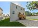 Exterior of home features a well-manicured lawn, and brick paved area with stairs leading to a deck at 7513 S Sherrill St, Tampa, FL 33616