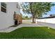 Landscaped backyard featuring a spacious lawn, brick paved area, white fence and mature shade tree at 7513 S Sherrill St, Tampa, FL 33616