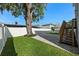 Backyard with manicured lawn, mature trees, brick patio, and white fencing for privacy at 7513 S Sherrill St, Tampa, FL 33616