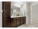 Bathroom showcasing double sinks with tiled floors, a large mirror, and a shower with tiled walls at 7513 S Sherrill St, Tampa, FL 33616