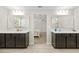 Spacious bathroom featuring double vanities, dark cabinetry, and a separate tub and shower at 7513 S Sherrill St, Tampa, FL 33616