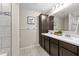 Bathroom featuring a double vanity, tile backsplash, decorative hooks and a tile floor at 7513 S Sherrill St, Tampa, FL 33616
