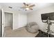 Bedroom featuring a ceiling fan, carpet floors, double-door closet and workout equipment at 7513 S Sherrill St, Tampa, FL 33616