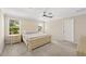 Bright bedroom with large window, ceiling fan, and neutral color scheme at 7513 S Sherrill St, Tampa, FL 33616