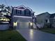 Inviting two-story home with landscape lighting, stone accents, and a decorative driveway at 7513 S Sherrill St, Tampa, FL 33616