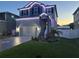 Charming two-story home featuring landscape lighting, stone accents, and a well-manicured lawn at 7513 S Sherrill St, Tampa, FL 33616
