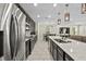 Modern kitchen with stainless steel appliances, dark cabinets, a large island, and stylish pendant lights at 7513 S Sherrill St, Tampa, FL 33616
