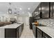 Stylish kitchen featuring dark cabinetry, stainless steel appliances, and a spacious island with marble countertops at 7513 S Sherrill St, Tampa, FL 33616