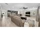 Open-concept living room features ample seating, tile floors, with view of modern kitchen and dining area at 7513 S Sherrill St, Tampa, FL 33616