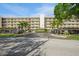 The building has a light exterior with a parking garage and many balconies under a mostly clear sky at 8198 Terrace Garden N Dr # 411, St Petersburg, FL 33709