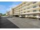 Spacious condo building with parking, featuring multiple stories and balconies under a bright sky showcasing its architecture at 8198 Terrace Garden N Dr # 411, St Petersburg, FL 33709