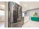 Kitchen with black stainless fridge and modern cabinets flows into the laundry room at 8198 Terrace Garden N Dr # 411, St Petersburg, FL 33709
