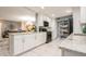 Modern kitchen with white cabinets, marble floor, and black appliances flows into dining room at 8198 Terrace Garden N Dr # 411, St Petersburg, FL 33709