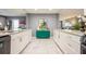 Kitchen has white cabinets, granite countertops, marble flooring, and bright teal cabinetry at 8198 Terrace Garden N Dr # 411, St Petersburg, FL 33709