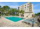 Community pool with inviting lounge chairs and building in the background, surrounded by lush greenery creating an ideal retreat at 8198 Terrace Garden N Dr # 411, St Petersburg, FL 33709