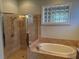 Bathroom with a soaking tub, glass shower and a double vanity with granite countertop at 832 King Leon Way, Sun City Center, FL 33573