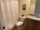 Bathroom with toilet, shower with curtain, vanity with granite countertop and mirror at 832 King Leon Way, Sun City Center, FL 33573