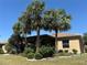 Charming home exterior with well-manicured landscaping and mature palm trees in a verdant lawn at 832 King Leon Way, Sun City Center, FL 33573