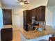 This kitchen features granite countertops, dark wood cabinetry, stainless steel appliances, and tile flooring at 832 King Leon Way, Sun City Center, FL 33573