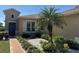 Close up of the front garden featuring tropical landscaping with pavers and stucco exterior at 832 King Leon Way, Sun City Center, FL 33573