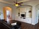 A cozy living room with custom built-ins, hardwood floors, ceiling fan, and neutral color palette at 832 King Leon Way, Sun City Center, FL 33573