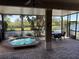 Enclosed patio featuring a spa, a table and chairs, and views of the pond at 832 King Leon Way, Sun City Center, FL 33573