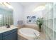 Bright bathroom featuring a soaking tub, decorative glass block, blue accents and a large window for natural light at 8376 Golden Prairie Dr, Tampa, FL 33647
