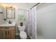 Bathroom featuring a single sink vanity, toilet, large mirror, and a walk-in shower with decorative tile at 8376 Golden Prairie Dr, Tampa, FL 33647