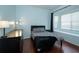 Stylish bedroom with a black headboard bed, bay window, and wood flooring at 8376 Golden Prairie Dr, Tampa, FL 33647