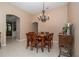 Charming dining room with a wooden table, six chairs, chandelier, and an arched doorway to another living space at 8376 Golden Prairie Dr, Tampa, FL 33647