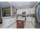 Spacious kitchen featuring an island, stainless steel appliances, white cabinets, and stone backsplash at 8376 Golden Prairie Dr, Tampa, FL 33647
