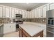 Well-equipped kitchen with stainless steel appliances, kitchen island, stone backsplash, and plenty of storage at 8376 Golden Prairie Dr, Tampa, FL 33647